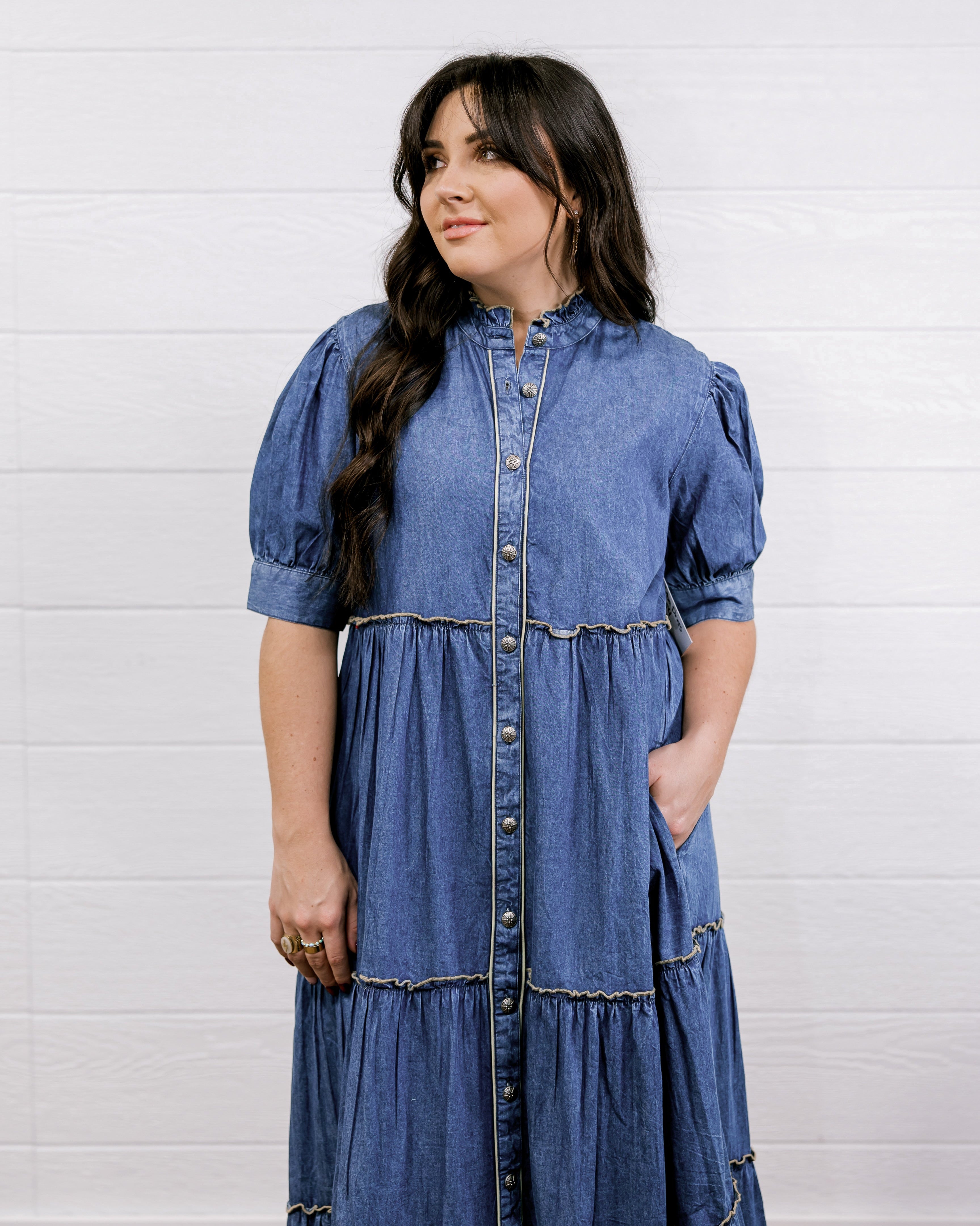 Woman wearing a blue denim dress against a white background