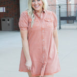 Woman with blonde hair wearing a burnt orange denim midi dress. 