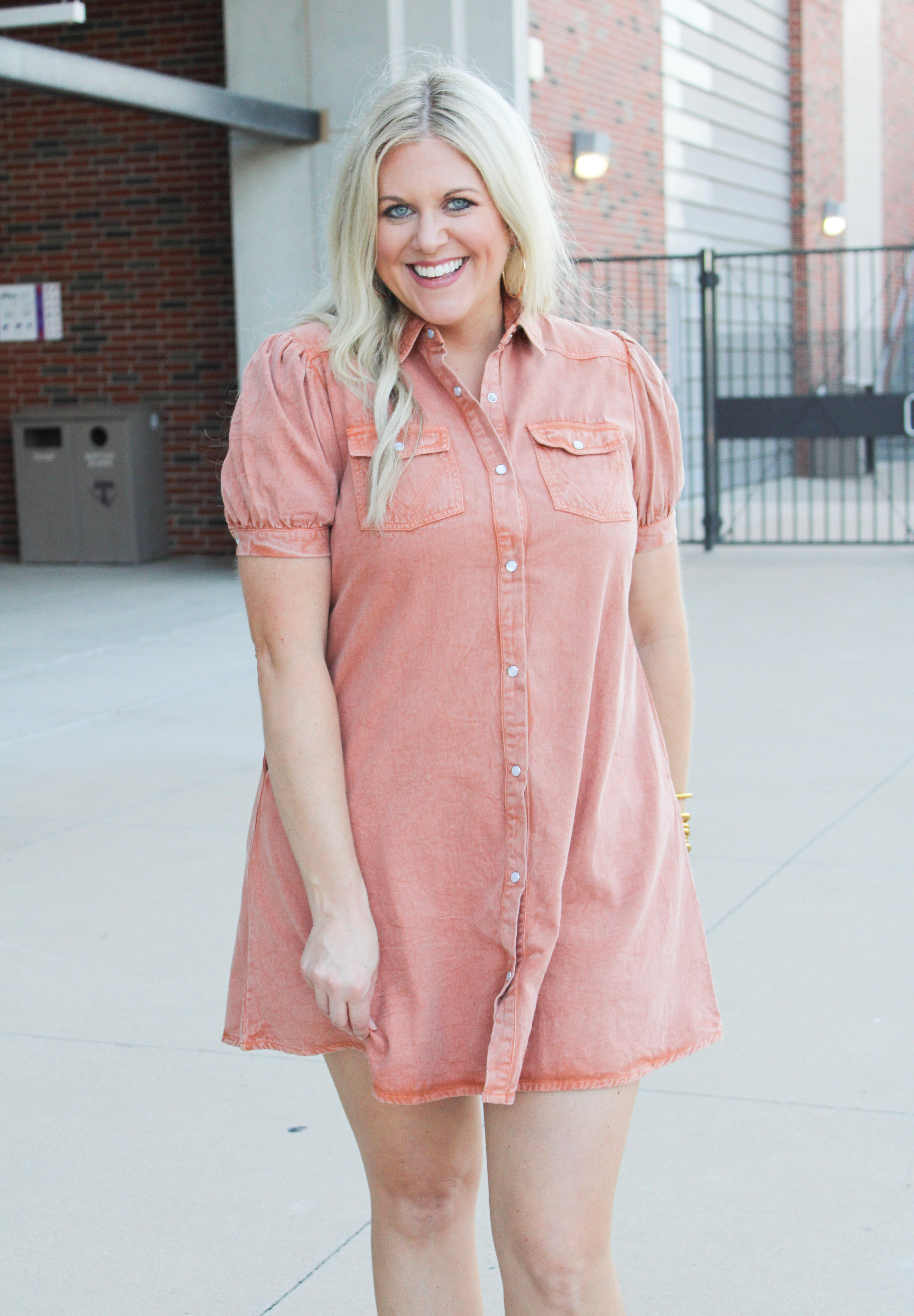 Woman with blonde hair wearing a burnt orange denim midi dress. 