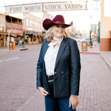 Women wearing a denim blazer on the city streets. 