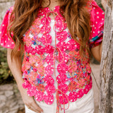 Up close of vest on women wearing white shorts outdoors. 