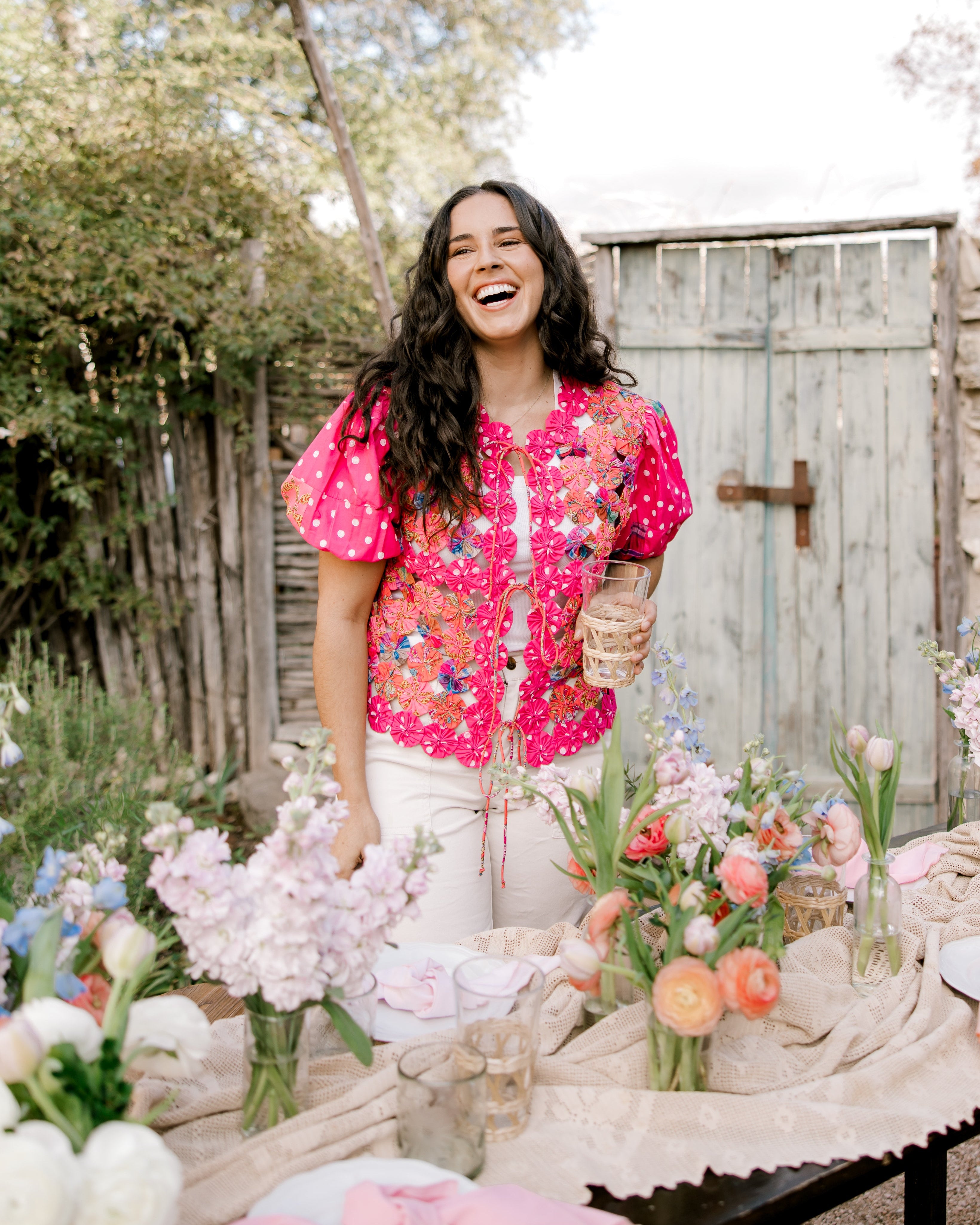 Women wearing a bright colored vest in a garden. 