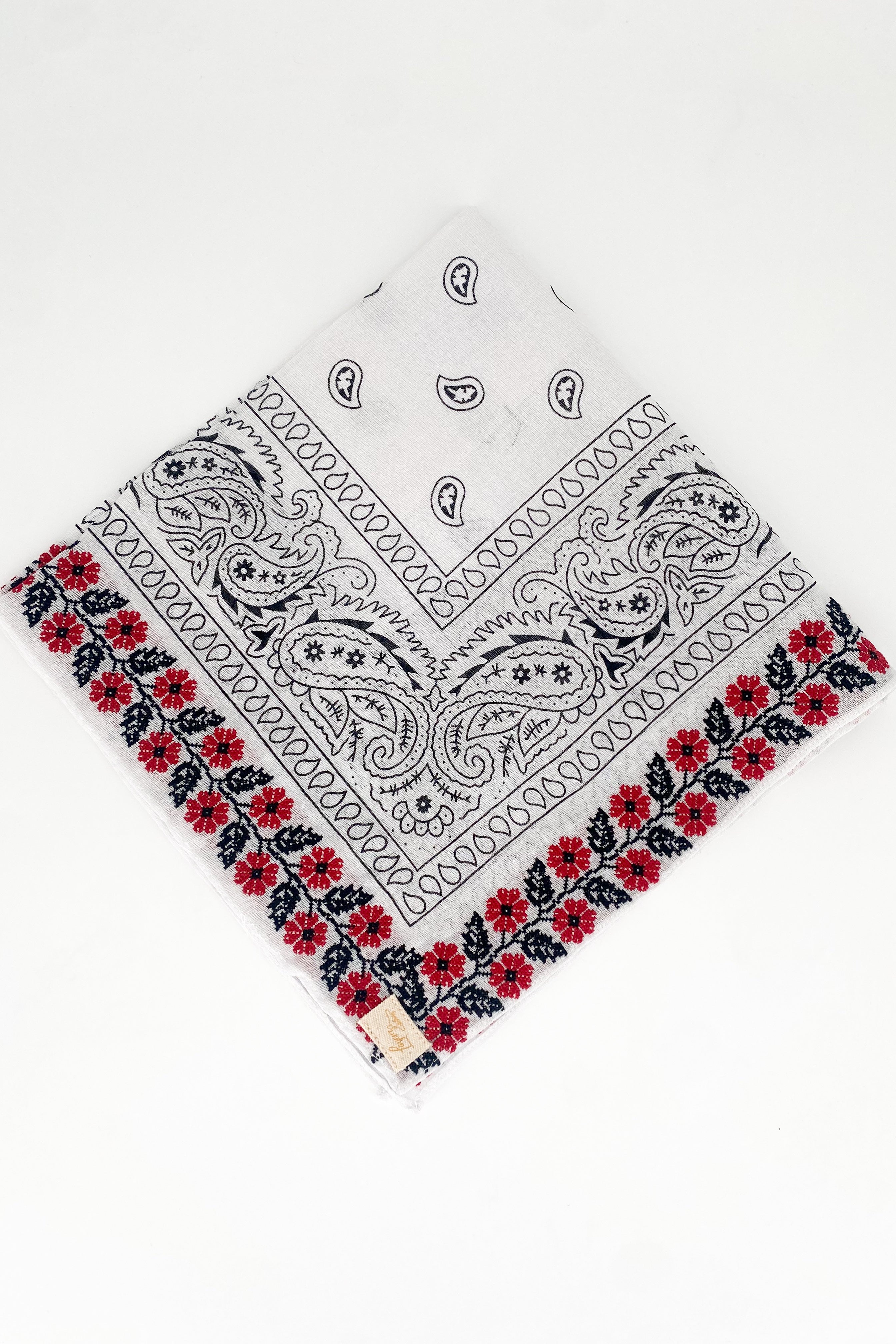 Zoomed out image of red floral frilly. Floral is embroidered. 