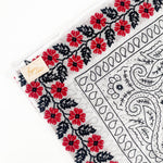 Zoomed in version of floral red frilly. Emphasis on the red floral embroidery. 