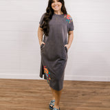 Long dress with embroidery on the shoulder and on the bottom corner showing the front