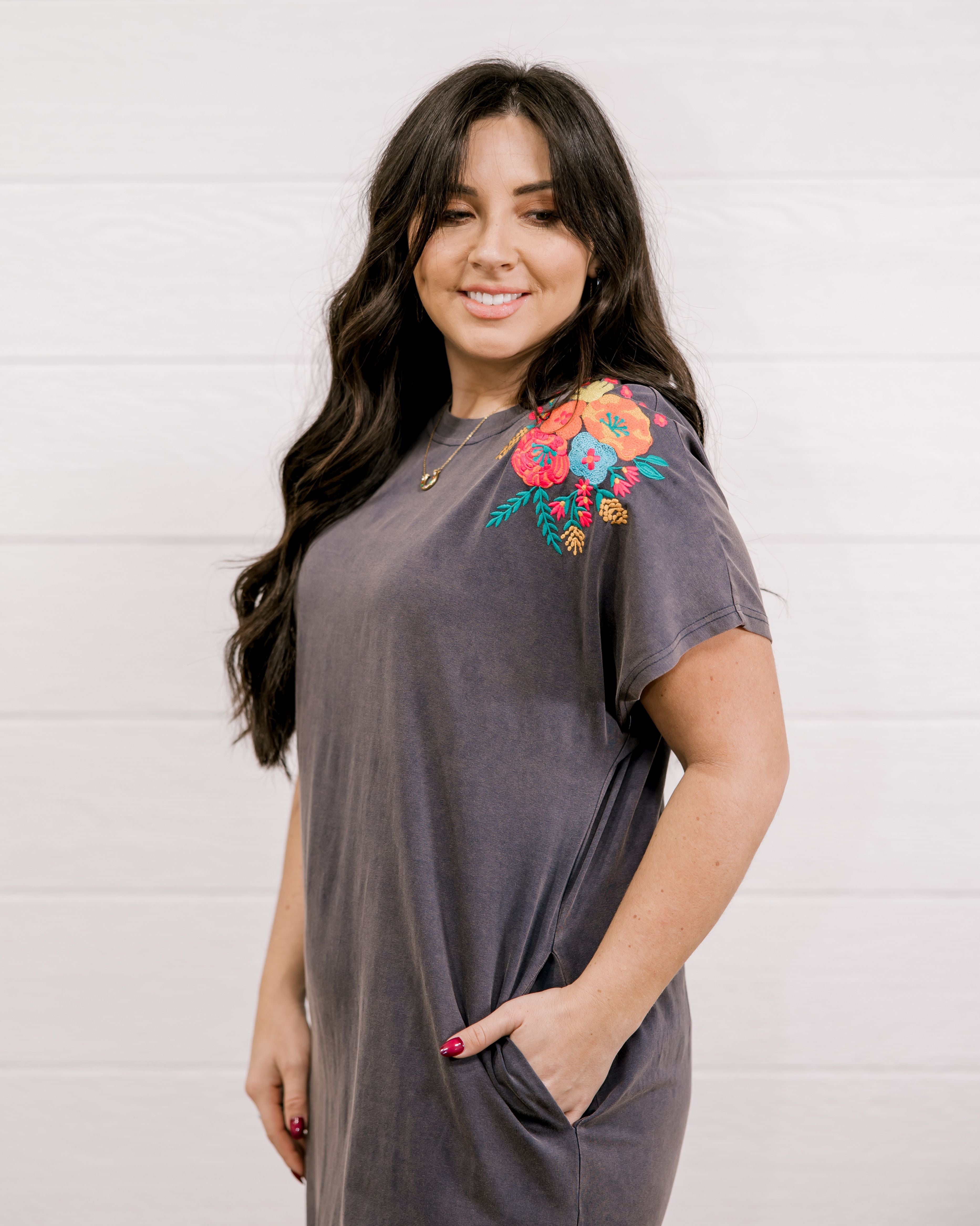 Long dress with embroidery on the shoulder and on the bottom corner showing the side and sleeve
