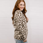 Woman wearing a leopard print sweater against a white background