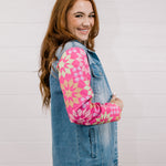 Side view of woman wearing a denim jacket with colorful quilted patchwork sleeves against a white background