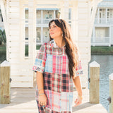 Woman with dark hair standing in a front profile position wearing the Paisley Tunic in a lifestyle scene. The focal point of this image in the entirety of the dress including the patched/favbric, and all embroidery. 