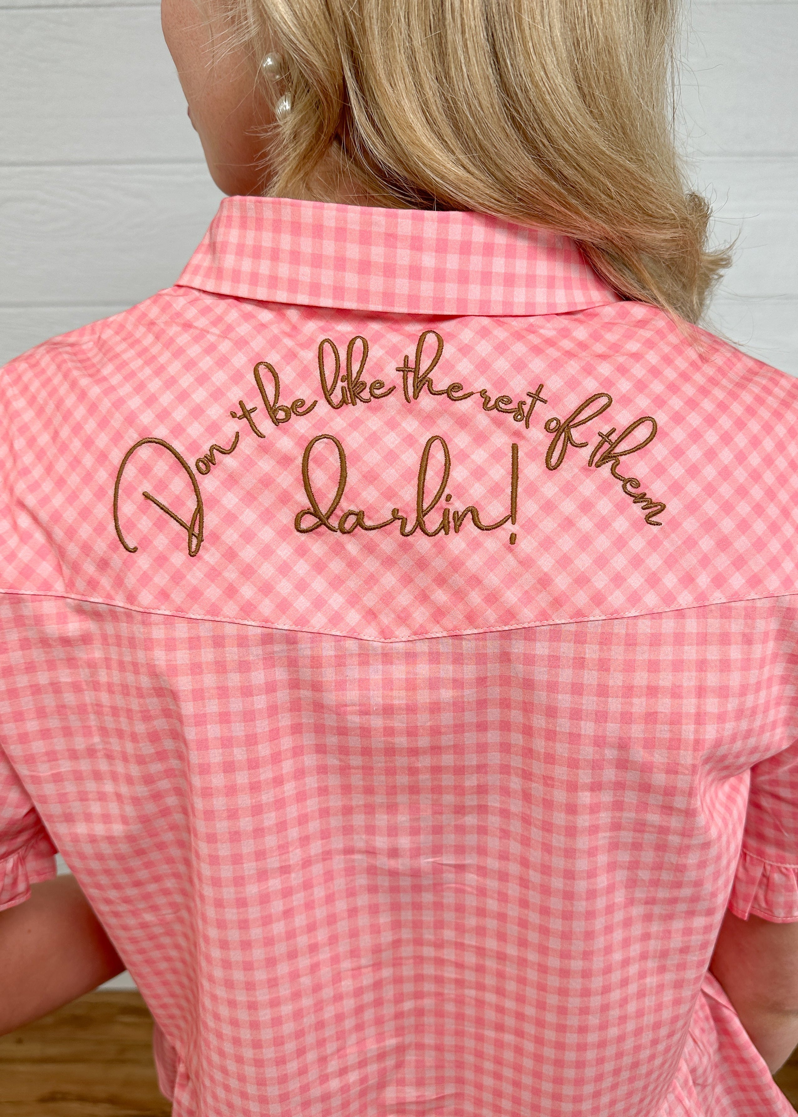 Back up-close view of the brown embroidery on back that says don't be like the rest of the darlin. 