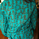 Woman with dark hair wearing the Sadie Body style with brown boots graphics along top and bow. Model paired this top with light-wash denim jeans. 