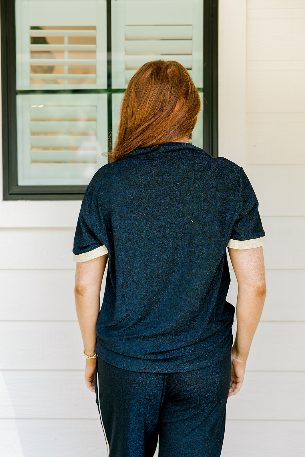 Woman with red hair wearing navy shimmer pants. Model paired this top with Sparkle Top-Navy. 