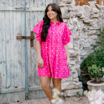 Woman wearing pink polka dot dress facing front