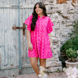 Woman wearing pink polka dot dress facing front