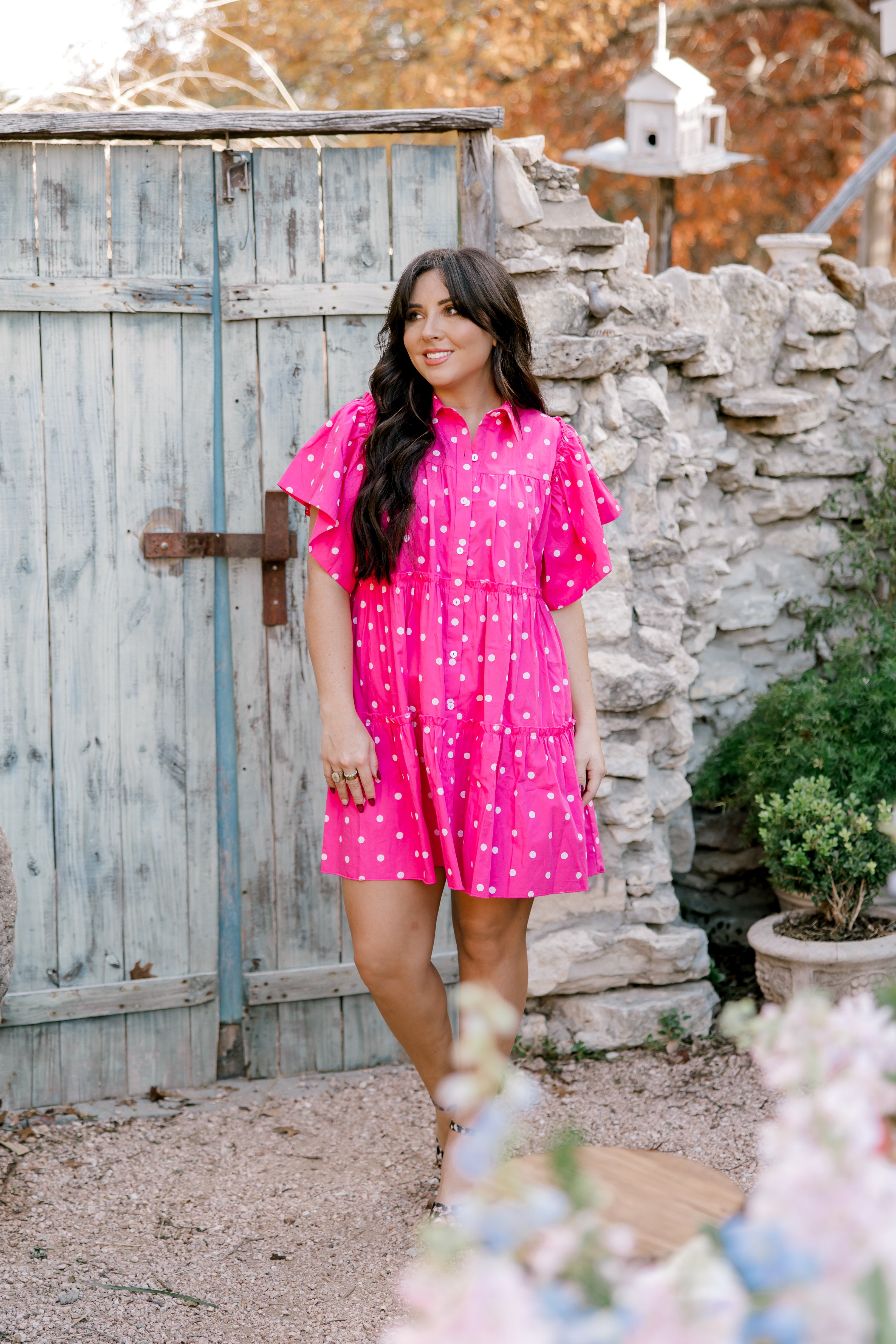 Woman wearing pink polka dot dress facing front