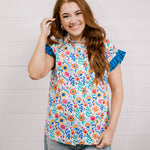 Women wearing a multi colored shirt with a collar and ruffle sleeves showing the front on a white background 