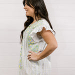 Woman wearing a white floral dress against a light background