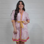 Women wearing pink and yellow floral dress twirling 