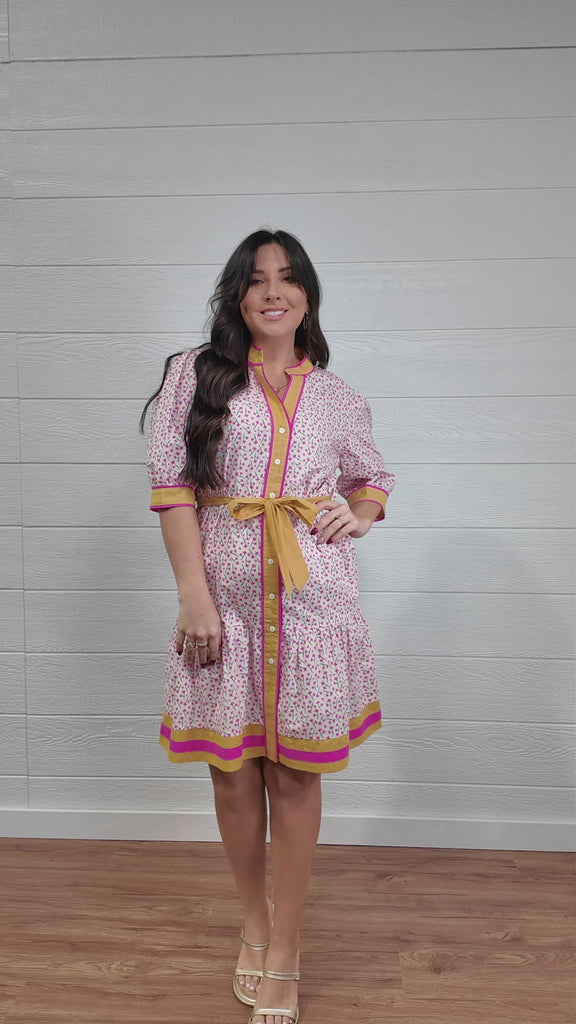Women wearing pink and yellow floral dress twirling 