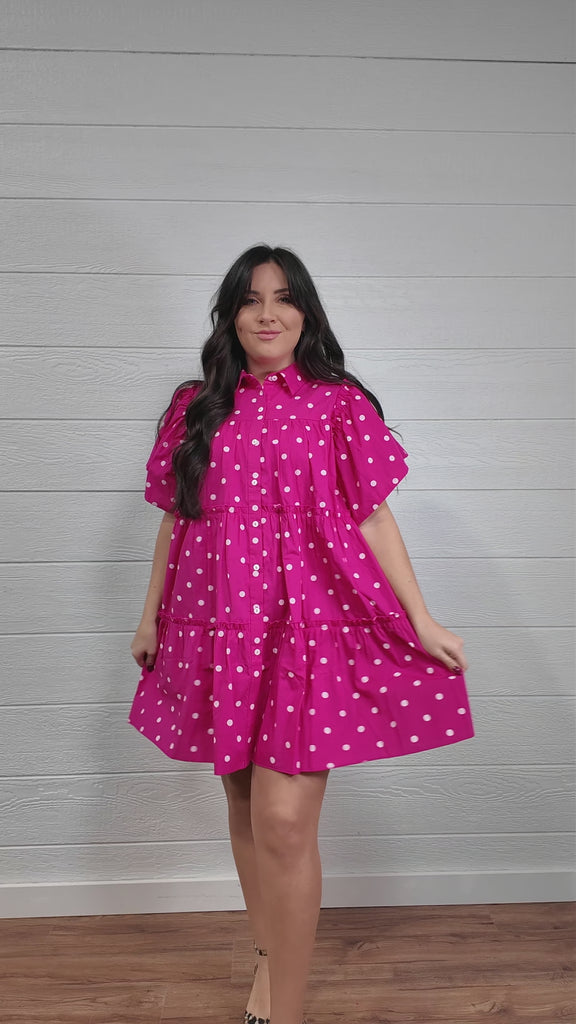 Women wearing pink polk a dot dress on white white twirling. 