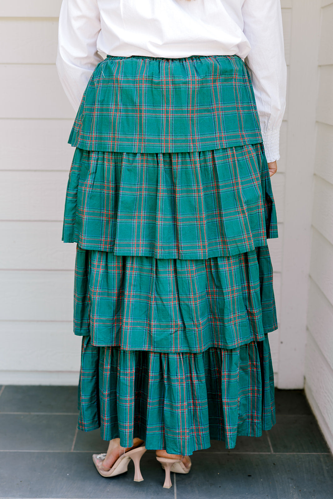 Woman wearing a green/red plaid maxi ruffle skirt with the Renee Top-White. 